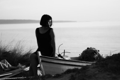 woman sitting on a boat, looking out to sea